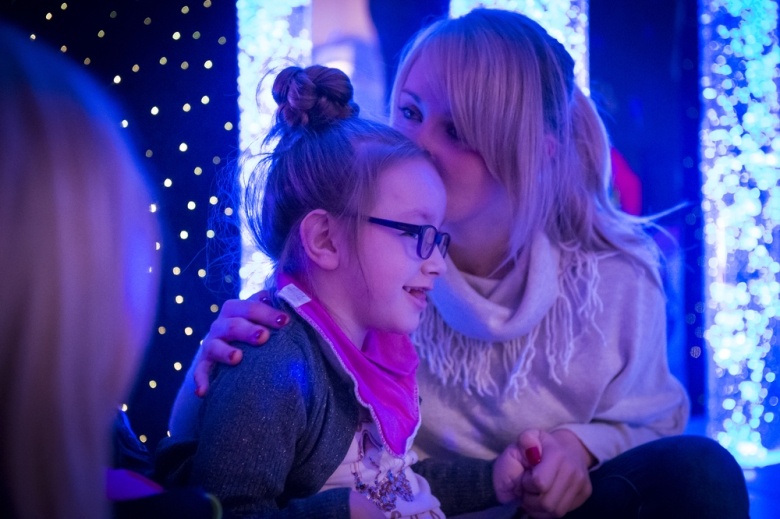 Little girl in sensory room with mum
