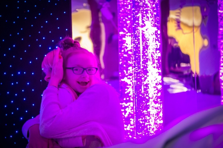 Little girl enjoying the lights in the sensory room
