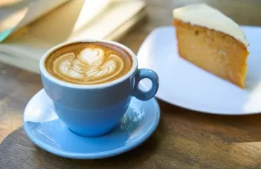 Coffee cup and saucer and slice of cake