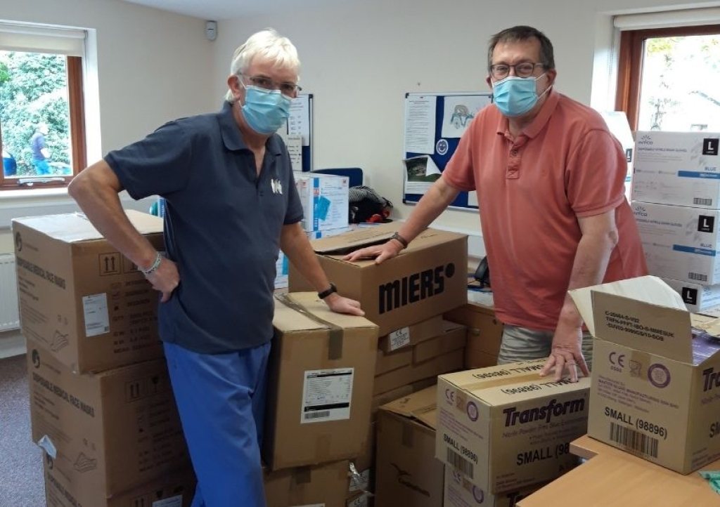 Volunteers Steve Warner and Lionel Murphy processing boxes of PPE supplies at Little Bridge House