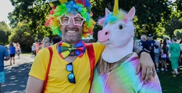 Two people dressed in rainbow outfits