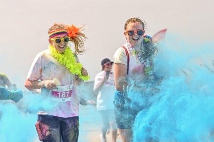 People having paint thrown at them whilst smiling and walking