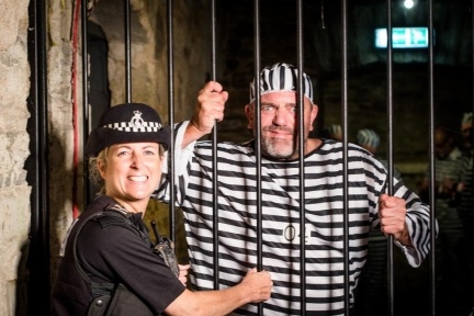 Prisoner in striped suit behind bars at Bodmin Jail