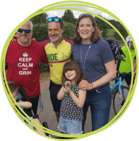 Five people smiling next to a man with a bike.