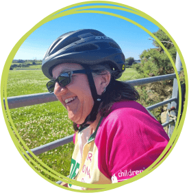 Chrissie Wakeley in cycle jersey and helmet