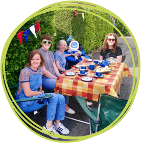 Group of people sat around a table outside