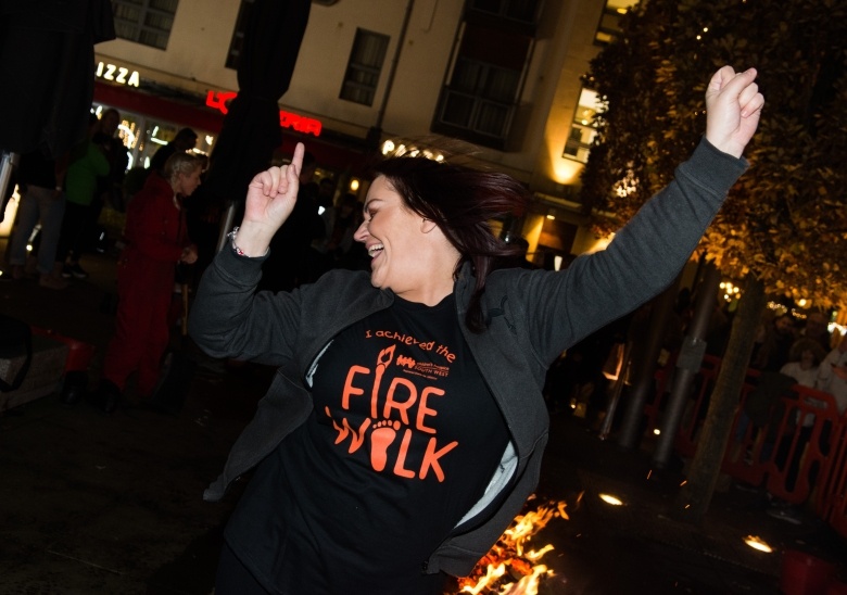 Woman smiling and celebrating after she completes her firewalk challenge for CHSW