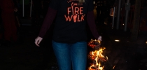 Woman wearing Firewalk t-shirt walking along hot coals thumbnail