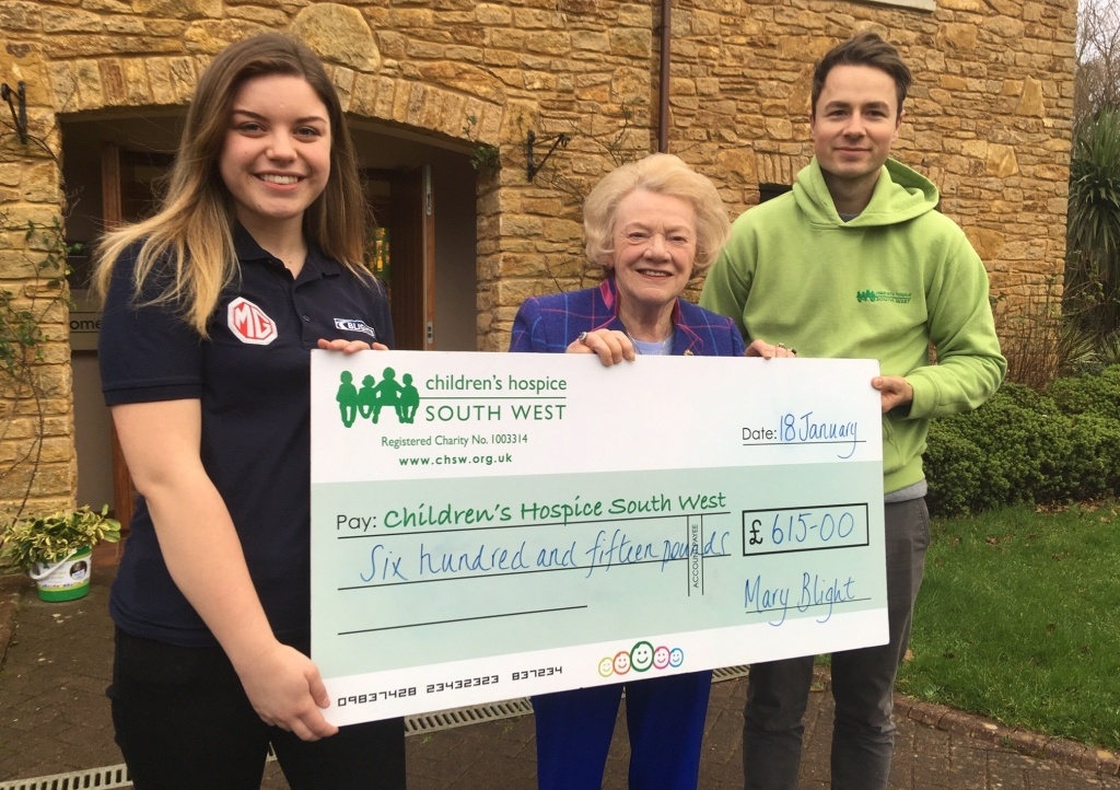 Mary Blight and Blights Motors service advisor Hannah Esau present the fundraising cheque to Children’s Hospice South West community fundraiser Josh Allan at Little Bridge House in Fremington.