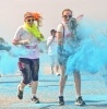 People having paint thrown at them whilst smiling and walking