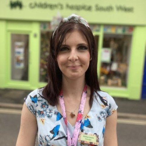 Woman standing in front of shop window smiling at the camera