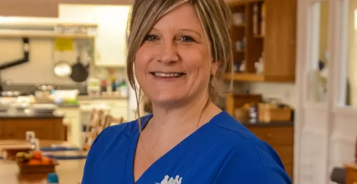 Smiling female nurse in blue scrubs