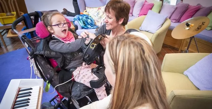 Girl in wheelchair and person playing guitar