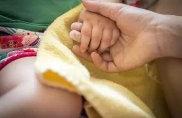 child and adult holding hands